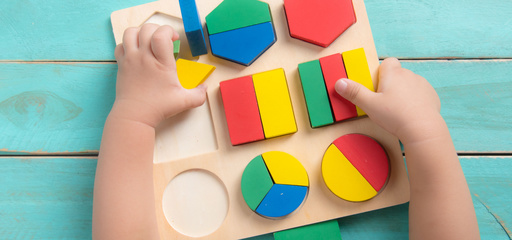 Toddler playing with block puzzles and shapes