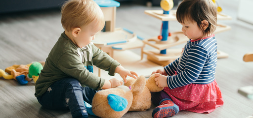 Two toddlers playing with toys in the playroom 