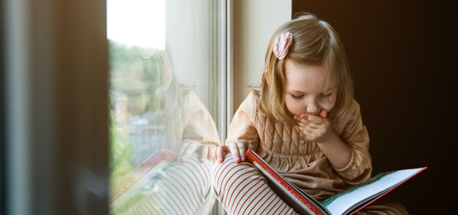 Toddler holding a book and reading