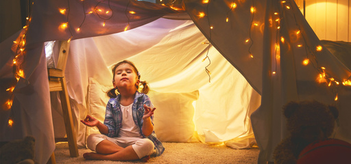 Toddler meditating in a tent in the living room