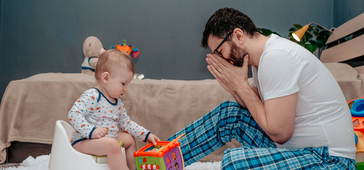 Young father teaching toddler how to use potty