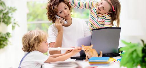 A parent working while toddlers play around her