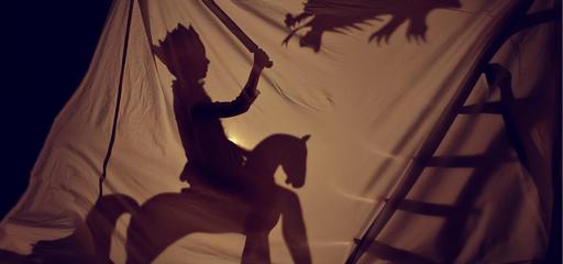 Toddler in a shadow play behind the curtain